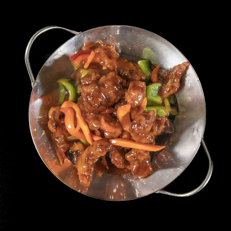 Sliced beef with peppers and carrot in a steel wok