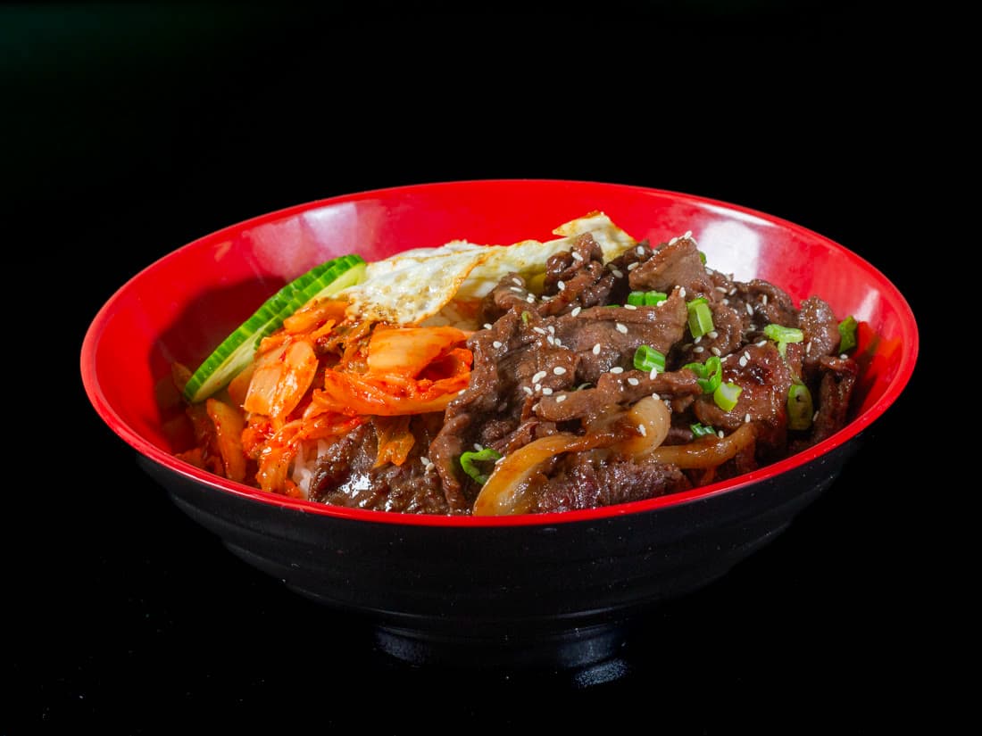 Korean beef bulgogi rice bowl with kimchi, cucumber and a fried egg