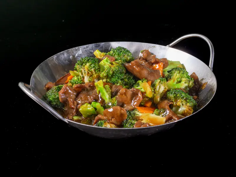 Broccoli and chicken in a savory garlic brown sauce in a steel wok