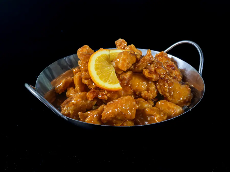 Orange chicken glazed and served in a steel wok