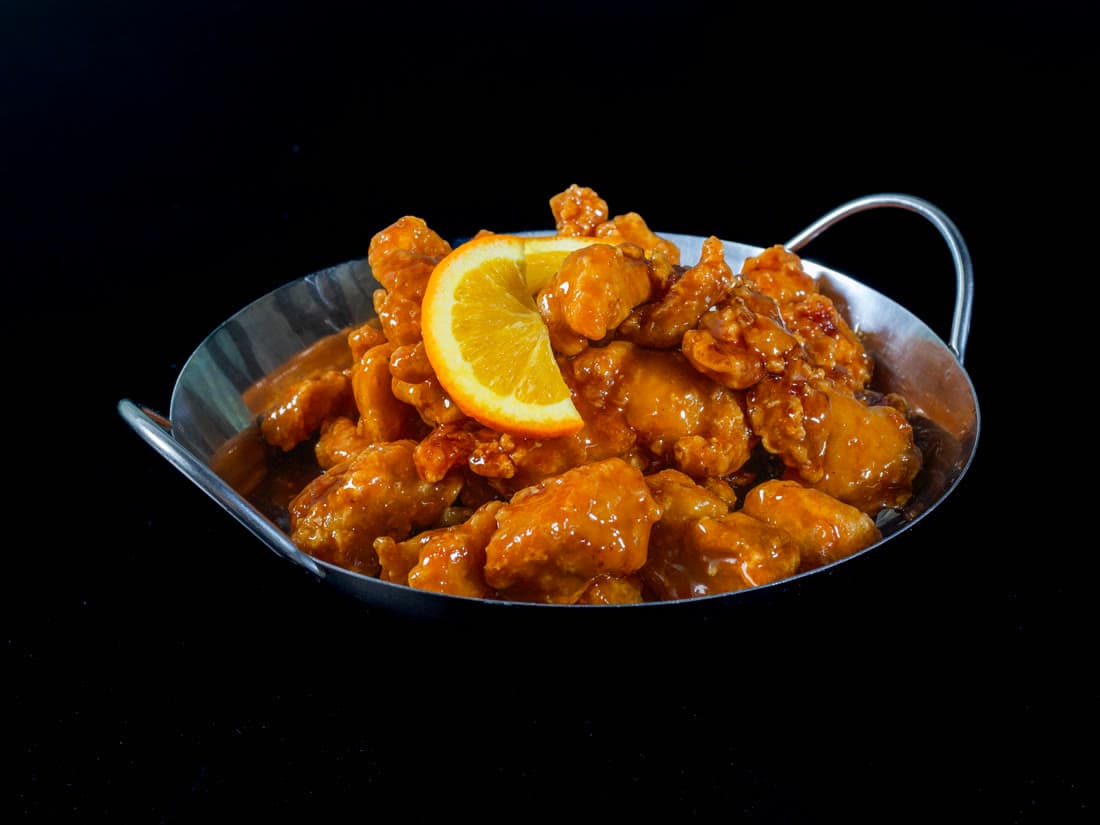 Orange chicken glazed and served in a steel wok